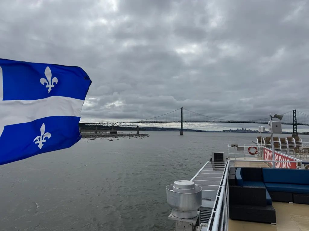 Pierre Laporte bridge viewed from the top deck of the ship, with Quebec’s flag waving into the wind